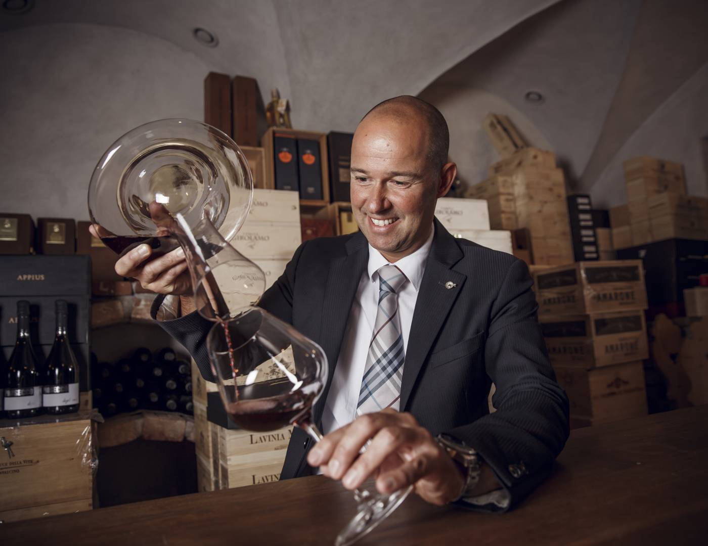 Sommelier che decanta un vino pregiato nel Pepikeller, la cantina dei vini dell’Hotel Erika a Tirolo