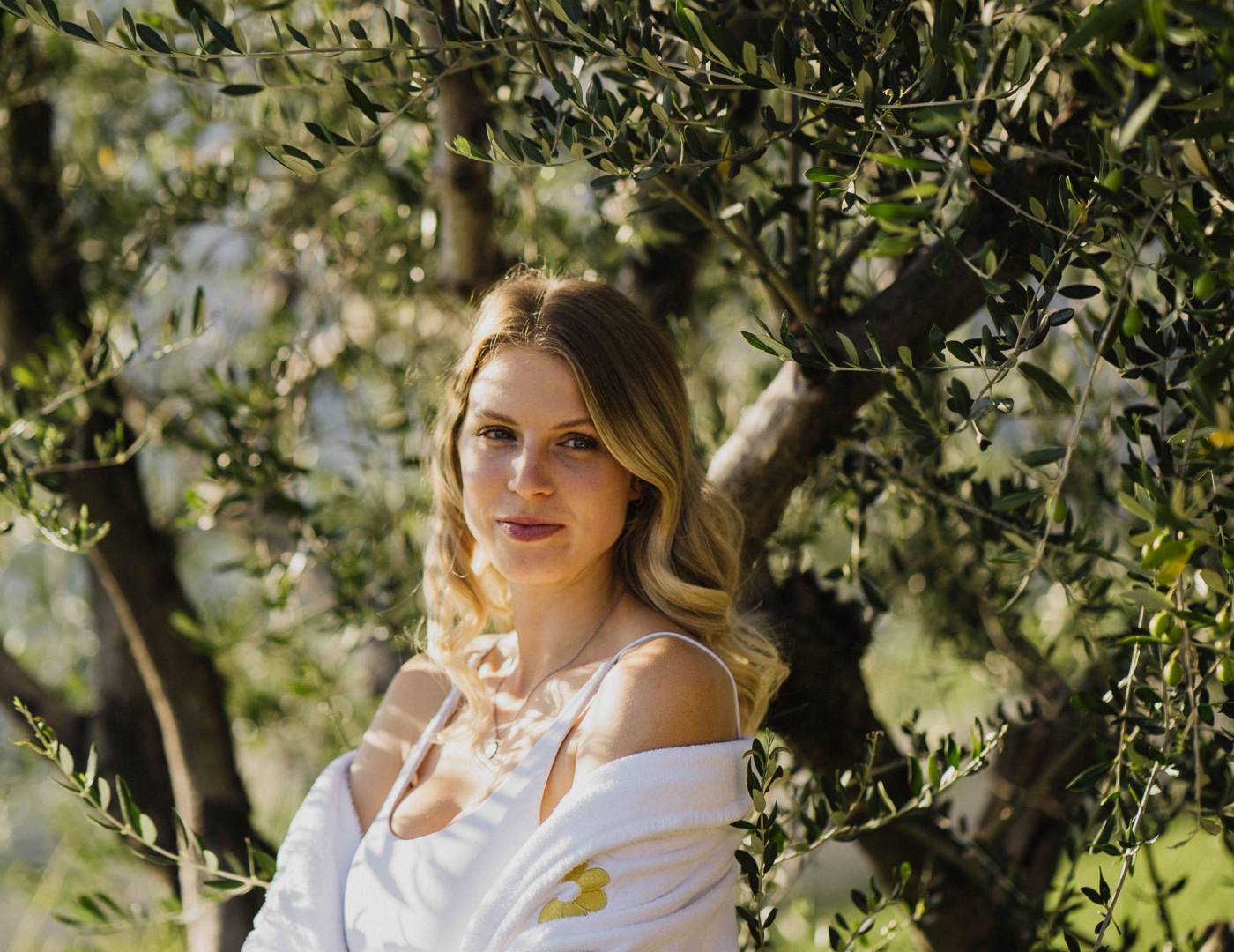 Frau entspannt im Erika-Olivengarten des Wellnesshotels in Dorf Tirol