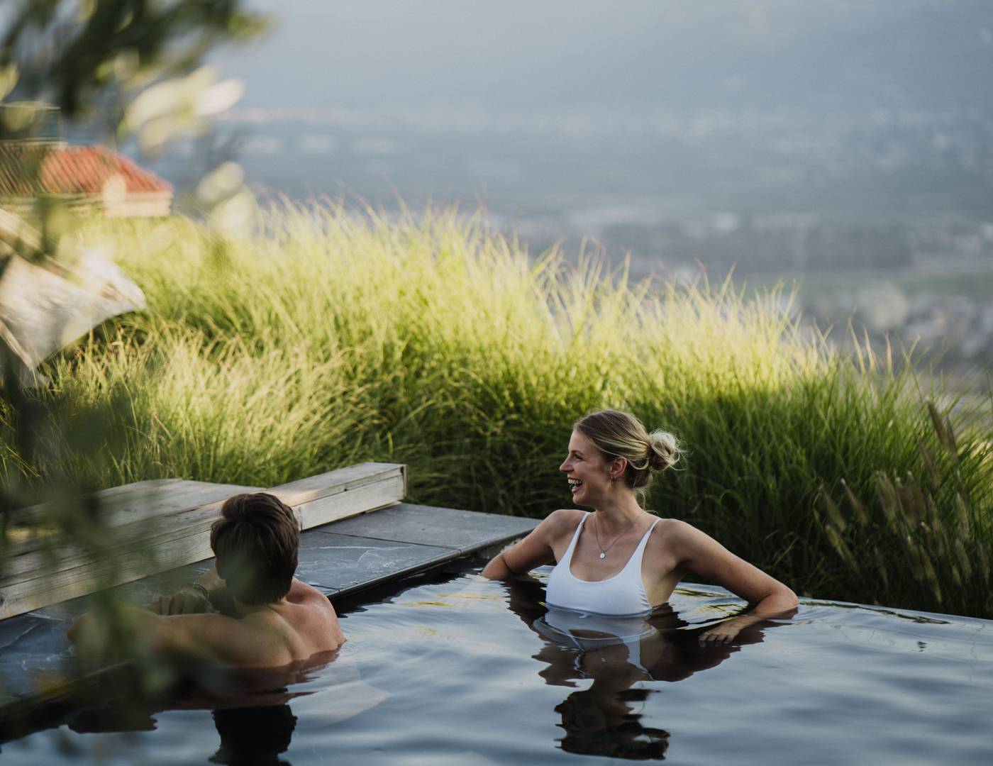 Paar im beheizten Außen-Infinitypool mit Bergblick im Wellnesshotel in Südtirol