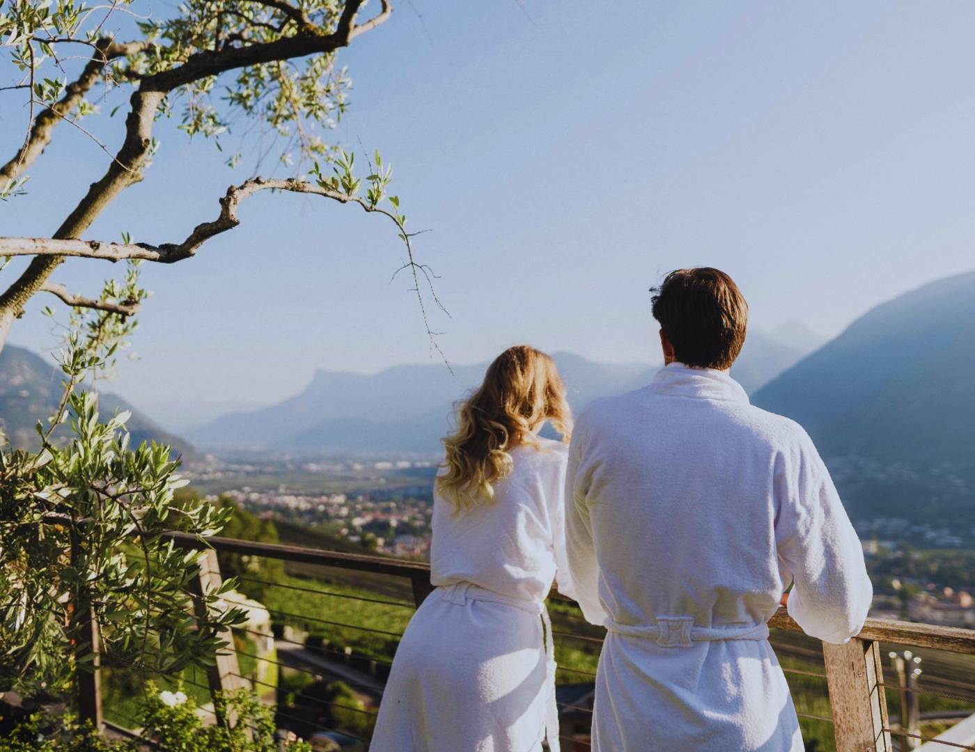 Paar steht im Erika-Garten und genießt das Panorama über Meran