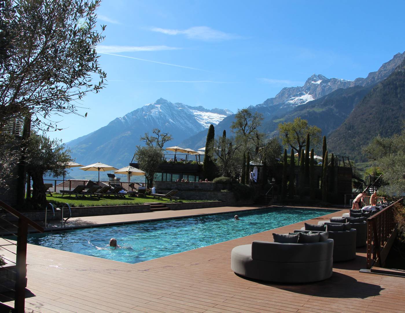Schwimmer ziehen ihre Bahnen im neuen 25-Meter-Schwimmbecken des Wellnesshotels bei Sonnenschein