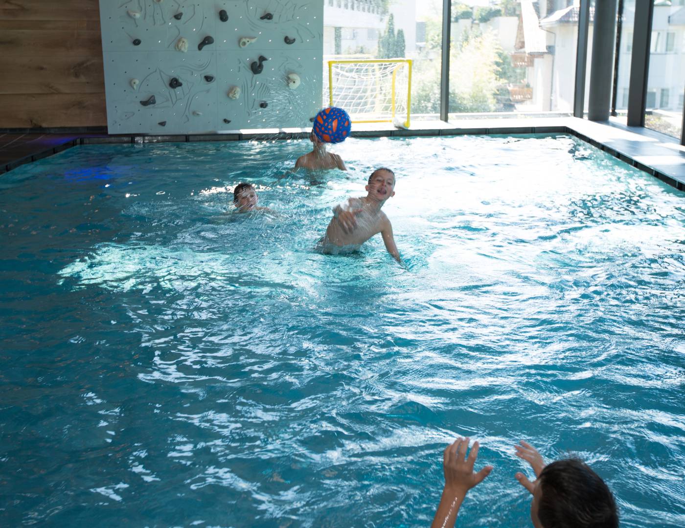 Boy throwing a ball to another boy in the children’s pool of a family hotel in South Tyrol
