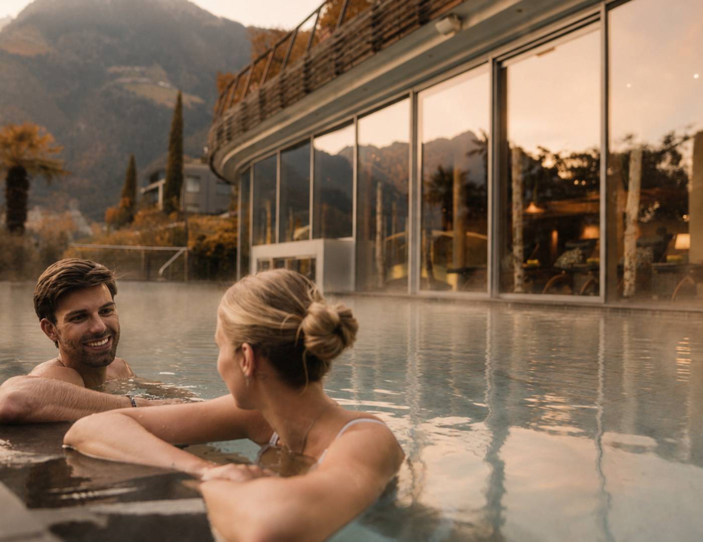 Pärchen genießt den Außenpool bei mildem Novemberwetter im Wellnesshotel in Südtirol