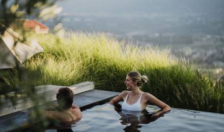 Paar im beheizten Außen-Infinitypool mit Bergblick im Wellnesshotel in Südtirol