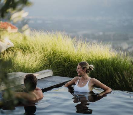Paar im beheizten Außen-Infinitypool mit Bergblick im Wellnesshotel in Südtirol