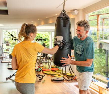 Pärchen trainiert an der Boxstation im Fitnessraum des Hotel Erika in Dorf Tirol
