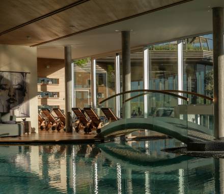Piscina coperta illuminata dal sole in un hotel benessere con elegante area pool
