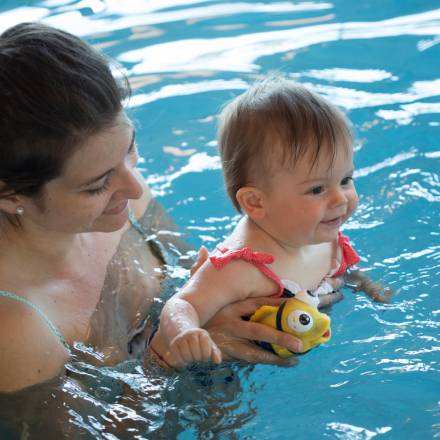 Mama mit Baby im warmen Kinderschwimmbad des Babyhotels in Südtirol