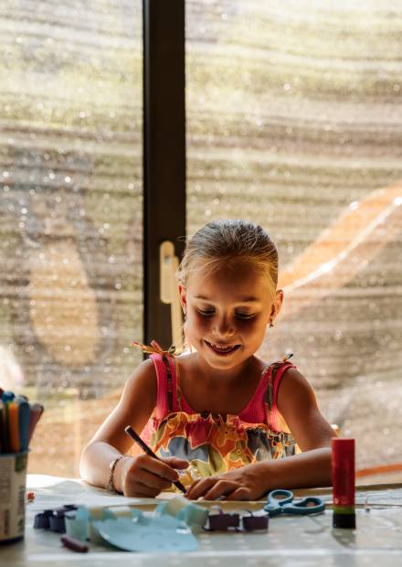 Mädchen bastelt im Kidsclub im Kinderhotel bei Meran