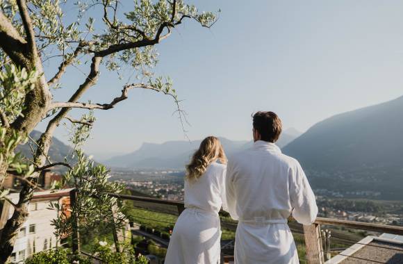 Paar in Bademänteln genießt die Aussicht auf Meran im Erika-Garten in Dorf Tirol, Südtirol