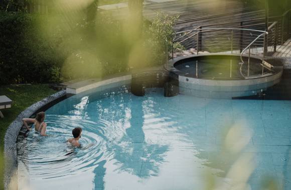 Pärchen entspannt im Freibad des Hotel in Südtirol mit Pool