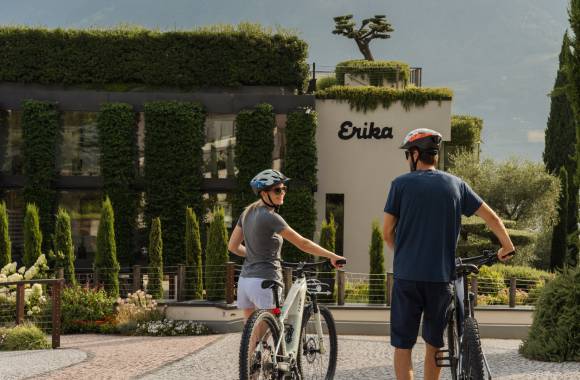Pärchen mit dem Fahrrad vor der Einfahrt des Spa & Relax Hotel Erika