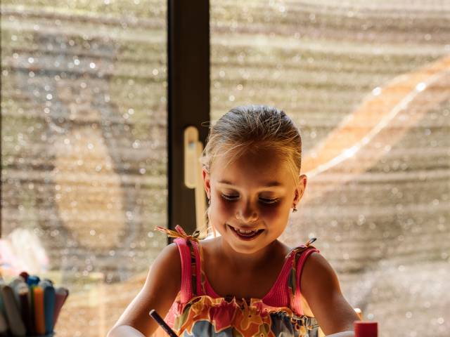 Mädchen bastelt im Kidsclub im Kinderhotel bei Meran