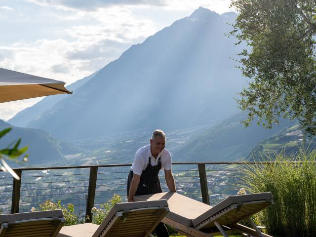 Hausmeister Martin richtet die Liegestühle im Erika-Garten des Hotel Erika in Dorf Tirol her