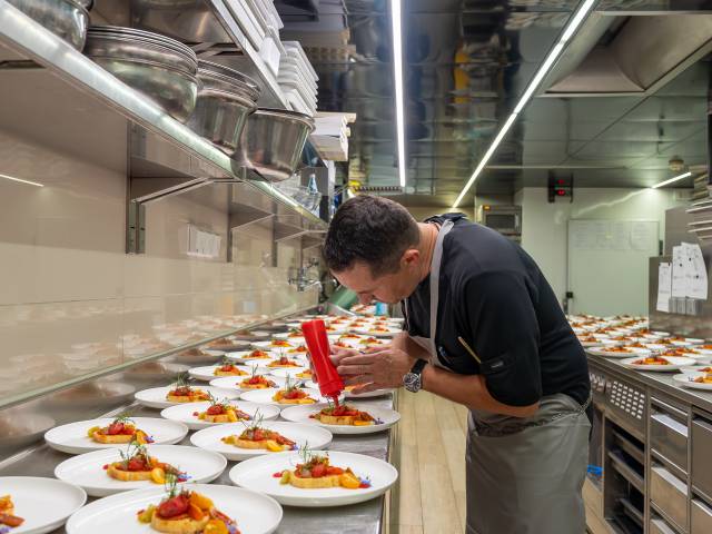 Küchenchef Manfred bereitet frische, raffinierte Speisen in der Gourmetküche des Hotel Erika in Dorf Tirol vor