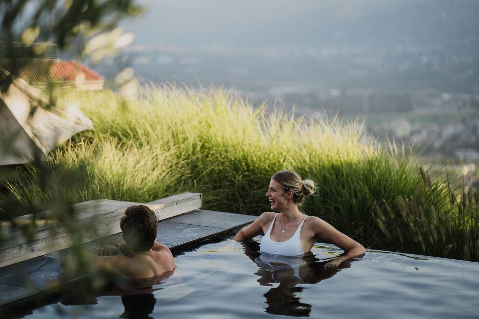Paar im beheizten Außen-Infinitypool mit Bergblick im Wellnesshotel in Südtirol