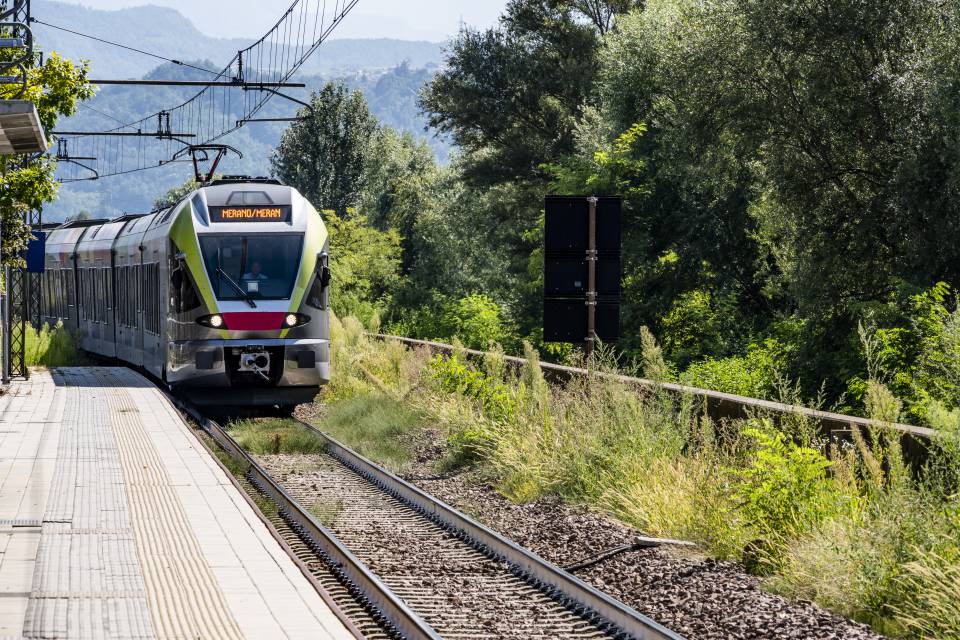 Treno rapido in sosta alla stazione di Merano, comodo arrivo in treno a Merano