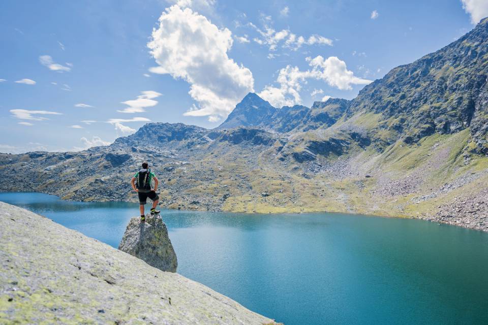 Uomo in vacanza escursionistica con vista sui Laghi di Sopranes sopra Merano in Alto Adige