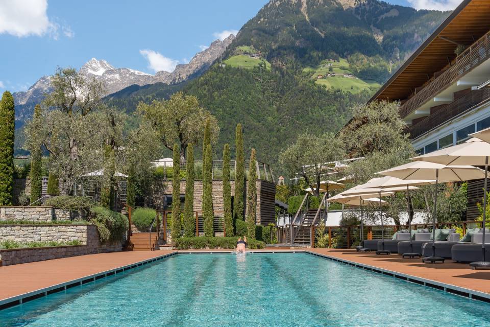 Schwimmer springt dynamisch in das 25-Meter-Sportbecken des Hotel Erika in Dorf Tirol