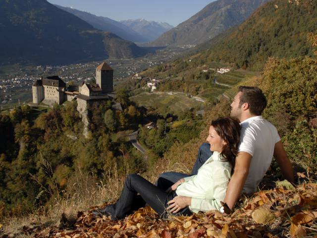 Paar entspannt mit Blick auf Schloss Tirol